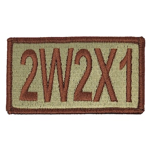 May include: A brown embroidered patch with a tan background. The patch has the text "2W2X1" on it.