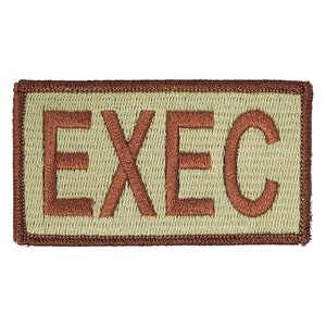 May include: A tan rectangular patch with a brown embroidered border and the word "EXEC" in brown.