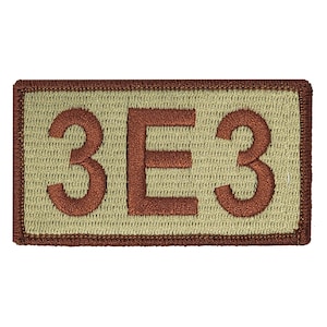 May include: A tan fabric patch with a brown embroidered border and the text "3E3" in brown thread.