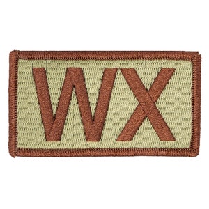 May include: A tan and brown embroidered patch with the letters "WX" in brown.