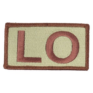 May include: A tan rectangular patch with a brown embroidered border and the letters "LO" in brown.