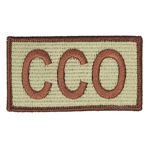 May include: A tan rectangular patch with a brown embroidered border and the letters "CCO" in brown.