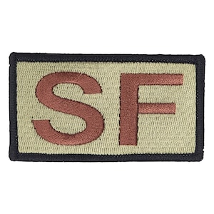 May include: A tan embroidered patch with the letters "SF" in brown thread.