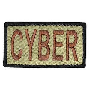 May include: A tan embroidered patch with black stitching around the edges. The patch says "CYBER" in brown thread.