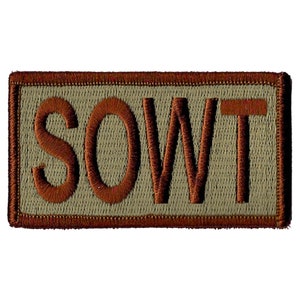 May include: A brown embroidered patch with the word "SOWT" in brown letters on a tan background.