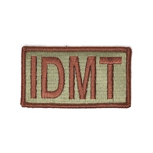 May include: A brown and green embroidered patch with the text "IDMT" in brown.