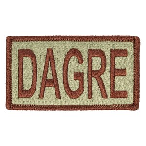 May include: A tan embroidered patch with a brown border. The patch says "DAGRE" in brown lettering.