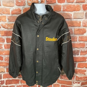 May include: Black leather jacket with a zipper closure and snap buttons. The jacket has a white and gold striped design on the sleeves and the word "Steelers" embroidered on the chest.