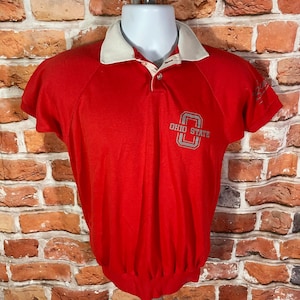 May include: Red short-sleeved polo shirt with a white collar and the words "Ohio State" in gray lettering on the front.