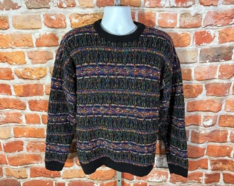 May include: A long-sleeve crew neck sweater featuring a black base with a multi-colored textured pattern of horizontal stripes in shades of blue, green, purple, and orange. The garment has a solid black ribbed collar, cuffs, and hemline.