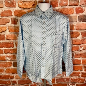 May include: A light blue long-sleeved button-down shirt with a small, all-over print of blue flowers.