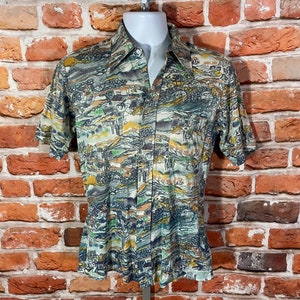 May include: A short-sleeved button-up shirt with a colorful abstract print featuring a landscape design. The shirt is made of a lightweight fabric and has a relaxed fit.
