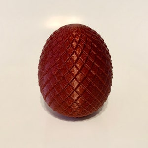 May include: A dark red dragon egg with a textured, diamond-shaped pattern.