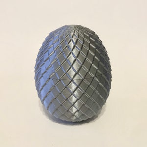 May include: A silver dragon egg with a textured, diamond-shaped pattern.