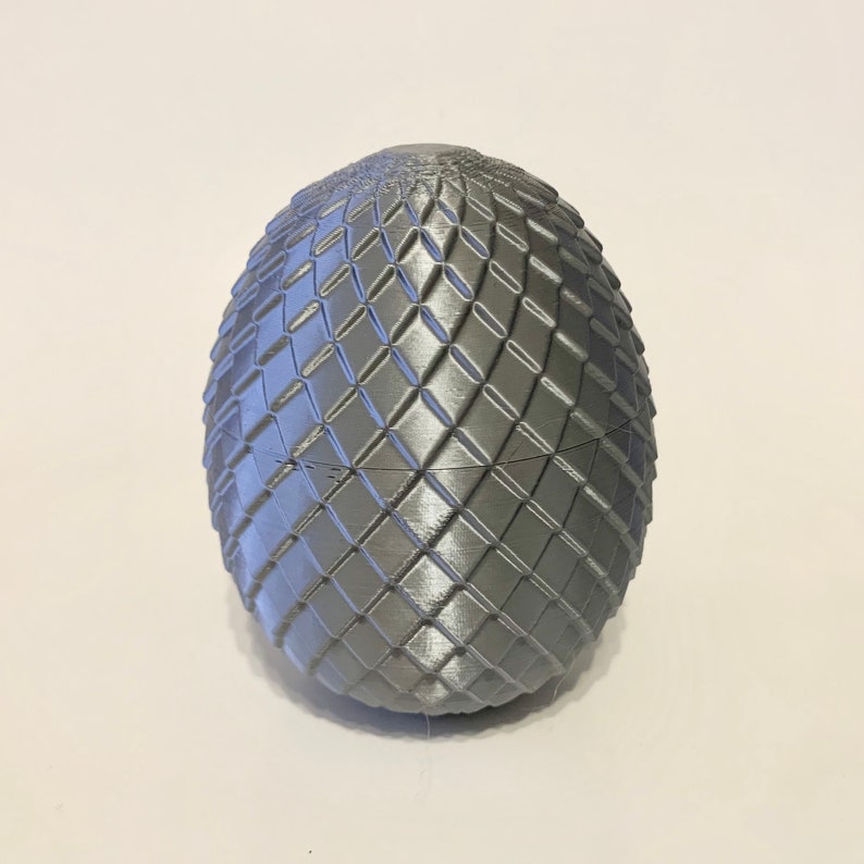 May include: A silver dragon egg with a textured, diamond-shaped pattern.