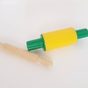 May include: A yellow and green rolling pin with a wooden rolling pin next to it.