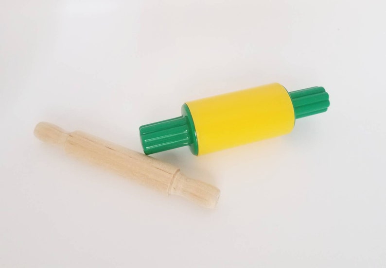 May include: A yellow and green rolling pin with a wooden rolling pin next to it.