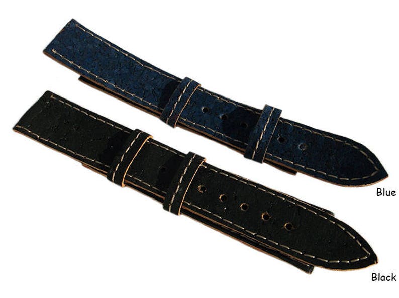 May include: Two watch straps made of cork, one blue and one black, with white stitching. The straps are shown against a white background.