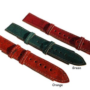 May include: Three watch straps made of cork with white stitching. The straps are red, green, and orange. The text "Red", "Green", and "Orange" is below each strap.