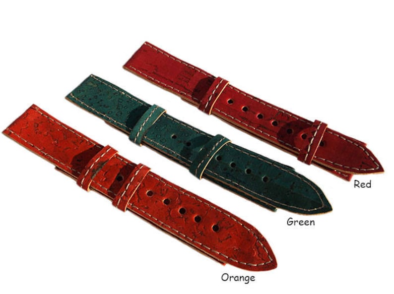 May include: Three watch straps made of cork with white stitching. The straps are red, green, and orange. The text "Red", "Green", and "Orange" is below each strap.