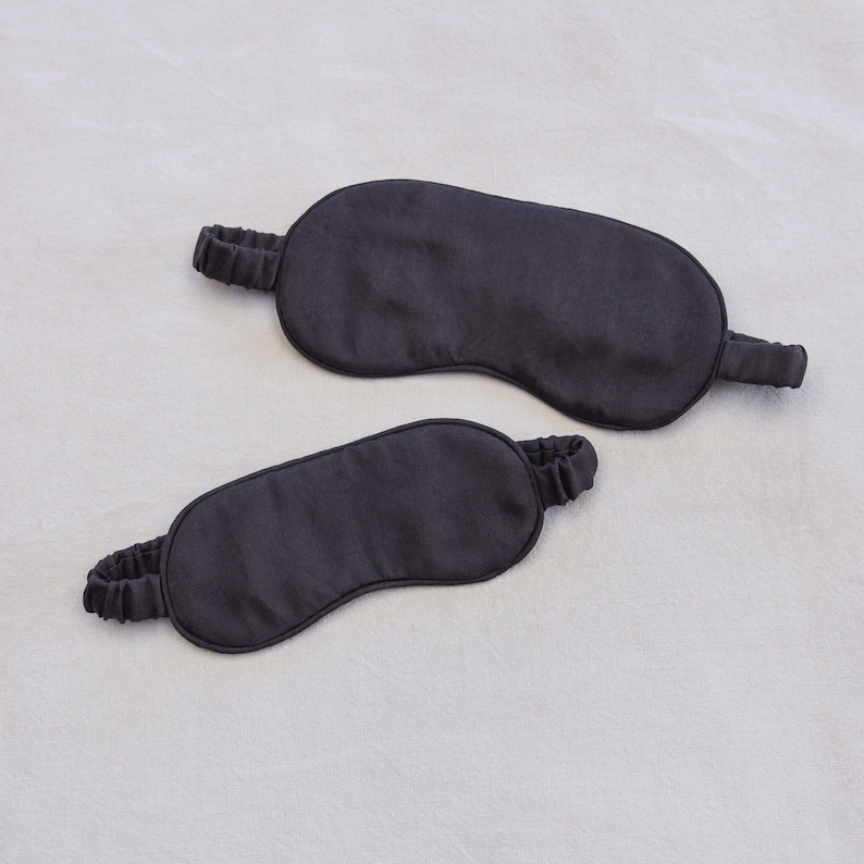 May include: Two black sleep masks made of soft fabric. The masks are designed to block out light and help you sleep.
