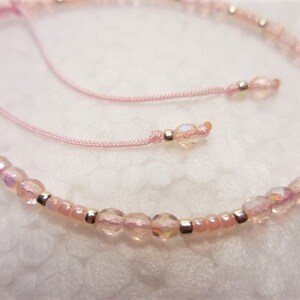 Puede incluir: Un brazalete de cuentas rosadas con cuentas plateadas y un cierre de cord&oacute;n rosa.