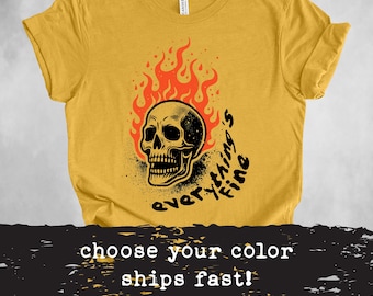 Könnte beinhalten: Ein gelbes T-Shirt mit einem schwarzen Totenkopf-Motiv in Flammen. Der Text "Everything's Fine" ist um den Totenkopf herum geschrieben.