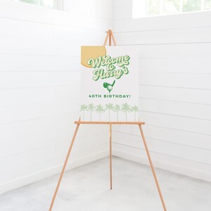 May include: Welcome to Harry's 40th Birthday sign with a golf ball and club graphic. The sign is on a wooden easel with a white background and green and yellow text.