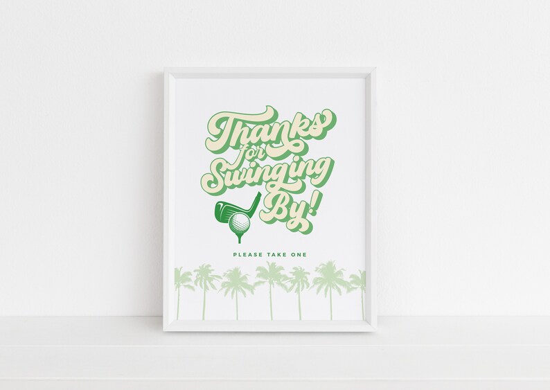 May include: A white framed print with green text that says "Thanks for Swinging By!" with a golf club and ball graphic. The text "Please Take One" is below the graphic. There are green palm trees at the bottom of the print.