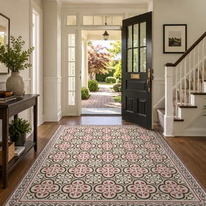 Peut inclure: Une entrée avec un tapis de sol à motifs floraux rouges, noirs et crème. Le tapis mène à une porte noire ouverte et à un escalier. Une console en bois foncé avec des décorations et une plante en pot se trouve à gauche.