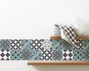May include: A decorative tile border with a blue, white, and black geometric pattern. The tile border is on a wooden shelf with white plates and a checkered dish towel.