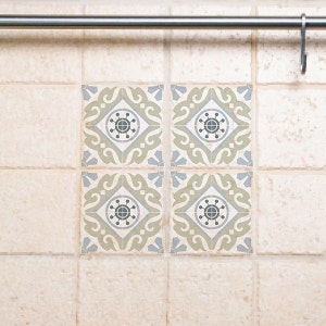 May include: Four decorative ceramic tiles with a light beige background and a green and blue geometric pattern. The tiles have a distressed look.