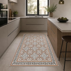 Peut inclure: Un tapis de cuisine rectangulaire avec un motif floral répété en blanc, gris et rouille. Le tapis a une bordure décorative et est posé sur un sol carrelé clair dans une cuisine moderne.