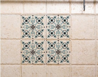 May include: Four square ceramic tiles with a blue, white, and black geometric pattern. The tiles have a vintage style and are perfect for adding a touch of elegance to any space.