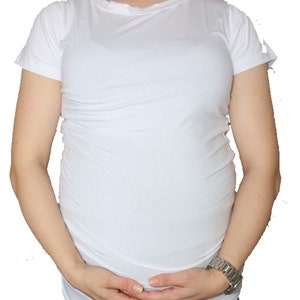 Puede incluir: Camiseta de maternidad blanca de manga corta y estilo ajustado.