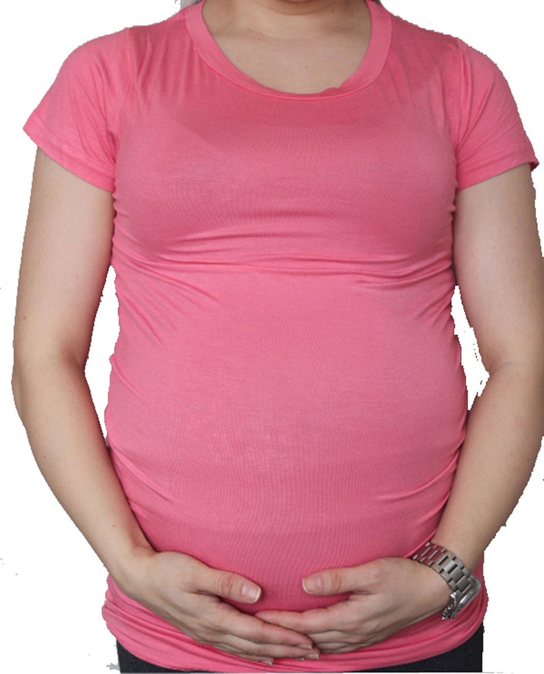 Puede incluir: Una camiseta de maternidad rosa de manga corta. La camiseta est&aacute; hecha de un tejido suave y el&aacute;stico y est&aacute; dise&ntilde;ada para ajustarse c&oacute;modamente sobre una barriga en crecimiento.