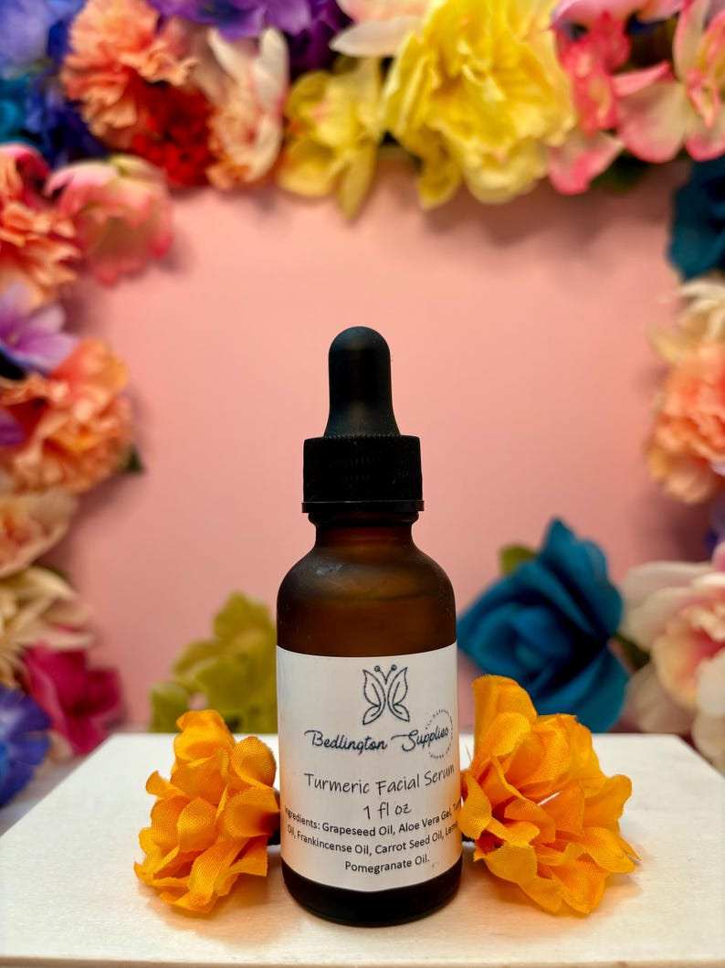 May include: A brown glass bottle with a black dropper top, labeled "Bedlington Supplies Turmeric Facial Serum 1 fl oz". The bottle is surrounded by yellow flowers.