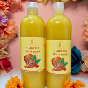 May include: Two clear plastic bottles of turmeric body wash with yellow liquid. The bottles have a yellow label with the text "Turmeric Body Wash" and a small image of turmeric root.