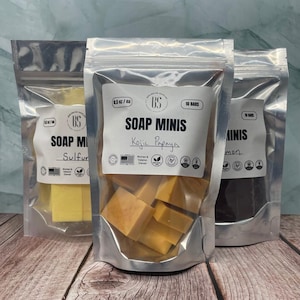 May include: Three silver pouches containing 10 bars of soap minis. The pouches are labeled with the text "SOAP MINIS" and the scents "Kojic Papaya", "Sulfur", and "Lemon".