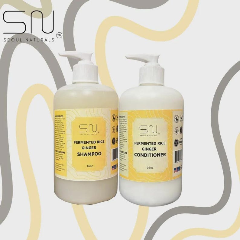 May include: Two 16oz bottles of Seoul Naturals hair care products with white pump dispensers. The left bottle contains light-colored Fermented Rice Ginger Shampoo, and the right bottle contains white Fermented Rice Ginger Conditioner with yellow labels.