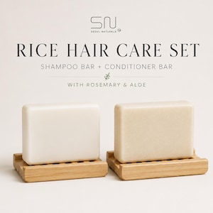 May include: A Rice Hair Care Set featuring a shampoo bar and a conditioner bar, displayed on wooden soap dishes. The bars are rectangular and light-colored. The text "RICE HAIR CARE SET" and "SHAMPOO BAR + CONDITIONER BAR" are visible.