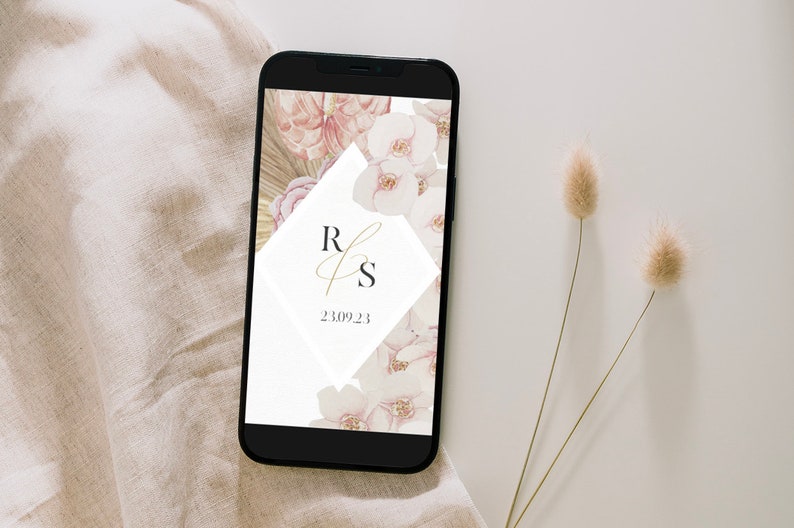 May include: A smartphone displaying a wedding invitation with a floral design and the initials "R & S" in gold script. The date "23.09.23" is also displayed on the screen.