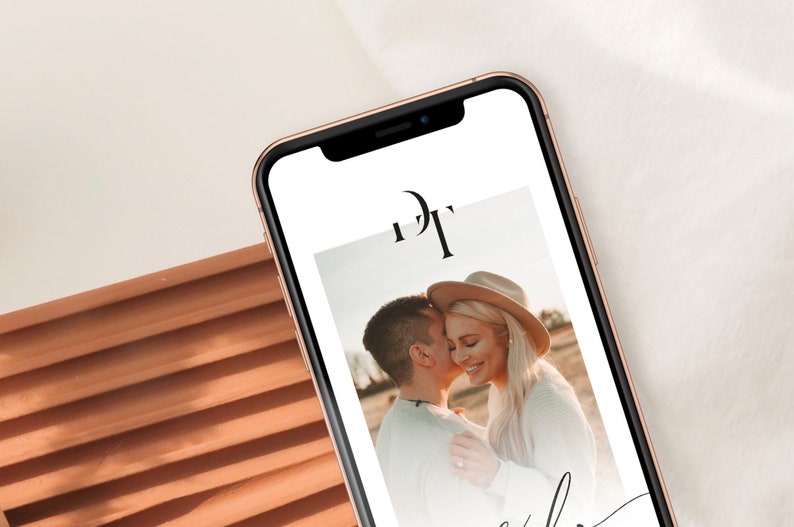 May include: A smartphone displaying a wedding announcement with a photo of a couple embracing. The announcement features the initials "D" and "T" in a modern font.
