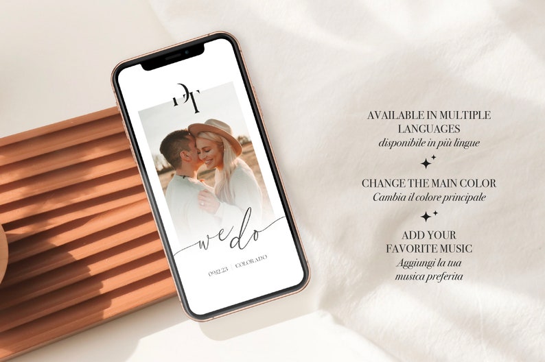 May include: A smartphone mockup displaying a wedding invitation template with a photo of a couple, the text "wedo", and the words "AVAILABLE IN MULTIPLE LANGUAGES" and "CHANGE THE MAIN COLOR" in black text on a white background.