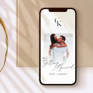 May include: A smartphone screen displaying a wedding announcement with a photo of a couple, the text "We're Getting Married", the date "09.22", and the location "California". The initials "C" and "K" are displayed in a circle at the top of the screen.