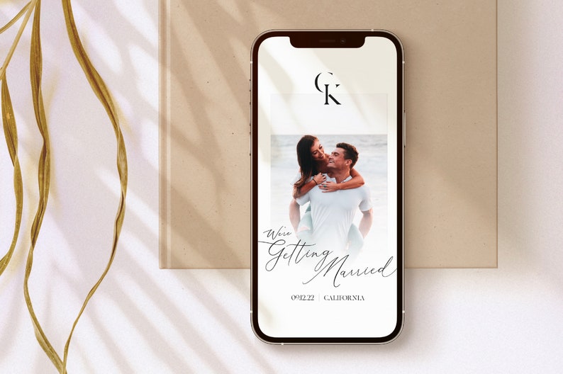May include: A smartphone screen displaying a wedding announcement with a photo of a couple, the text "We're Getting Married", the date "09.22", and the location "California". The initials "C" and "K" are displayed in a circle at the top of the screen.
