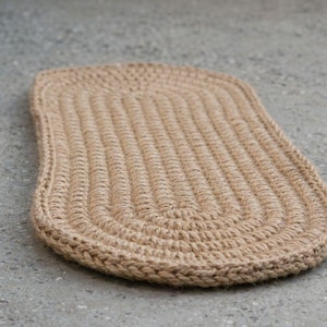 Oval jute stair tread made from natural materials, hand crocheted textured stair tread rug on modern stairs