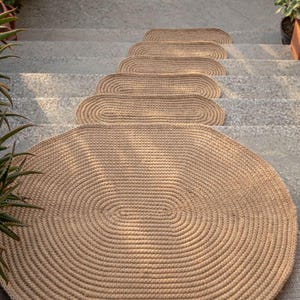 Oval jute stair treads paired with matching jute rugs, cohesive natural home decor collection