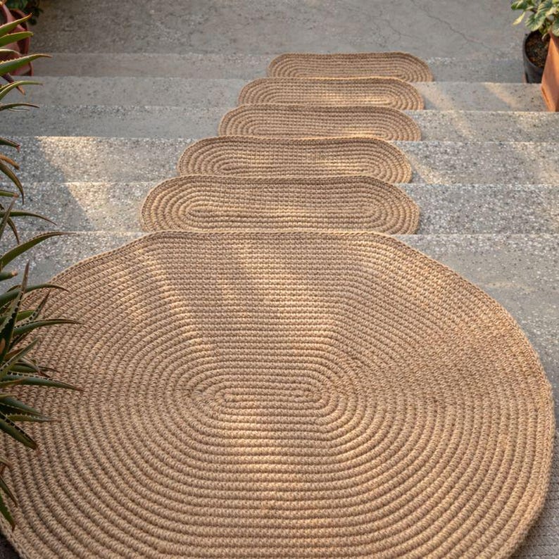 Oval jute stair treads paired with matching jute rugs, cohesive natural home decor collection