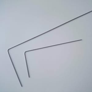 May include: Two silver metal bent wire pieces, one longer than the other, on a white background.